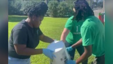 Community members clean up Hogans Creek after recent flooding