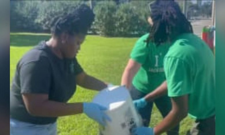 Community members clean up Hogans Creek after recent flooding